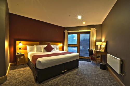 a hotel room with a large bed and a window at The Inn on Loch Lomond in Luss
