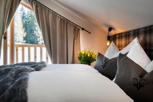 een slaapkamer met een bed met kussens en een raam bij Lerchpeuntgut Alpenfreud Apartments in Tamsweg