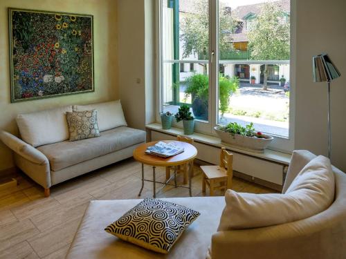 a living room with a couch and a table and a window at Hotel Garni Christl in Bad Griesbach