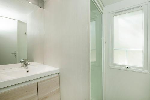 a white bathroom with a sink and a shower at Camping la Croix du Sud in Saint-Tropez