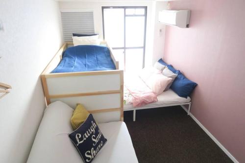 a small room with two bunk beds and a couch at A's Guest Room 303 in Osaka