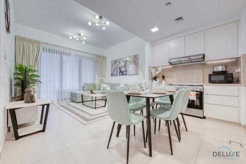 a kitchen and living room with a table and chairs at Exquisite 2BR at Zahra Breeze Dubailand by Deluxe Holiday Homes in Dubai