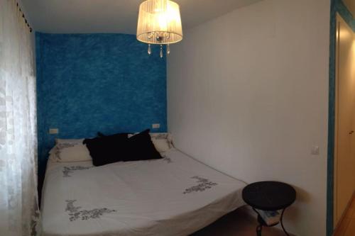 - une chambre dotée d'un lit avec un mur bleu dans l'établissement Casa junto al lago, à Jérica