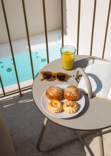a table with a plate of donuts and a glass of orange juice at Neratze Hammam Suites in Rethymno Town