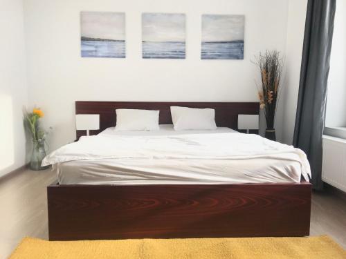 a bedroom with a large bed with white sheets at Orange Onix Apartaments in Bucharest