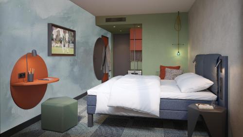 Dormitorio pequeño con cama y mesa en ibis Styles St Margrethen Bodensee, en Sankt Margrethen