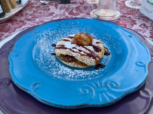 a blue plate with a pastry on a table at B&B Luxury Villa Olimpia Home Restaurant in Selva di Fasano