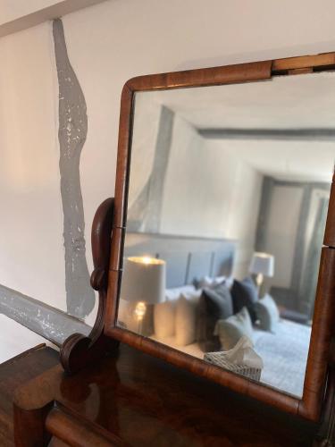 a mirror on top of a table with a couch at White Hart Hotel in Dorchester on Thames