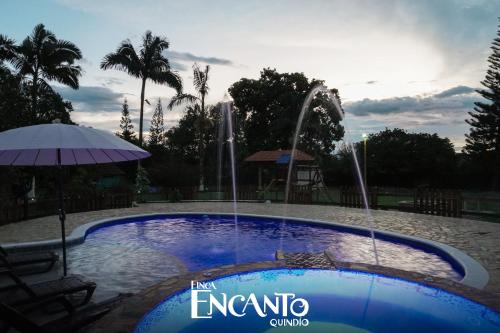 ein Schwimmbecken mit einem Springbrunnen in der Mitte in der Unterkunft FINCA HOTEL Encanto Quindio in La Tebaida