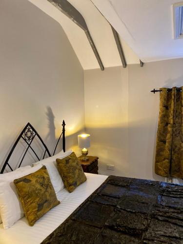 a bedroom with a bed with white sheets and pillows at White Hart Hotel in Dorchester on Thames