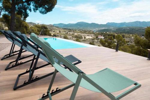 un groupe de chaises longues assises sur une terrasse à côté d'une piscine dans l'établissement Finca Bonaire Alicante, à Jijona