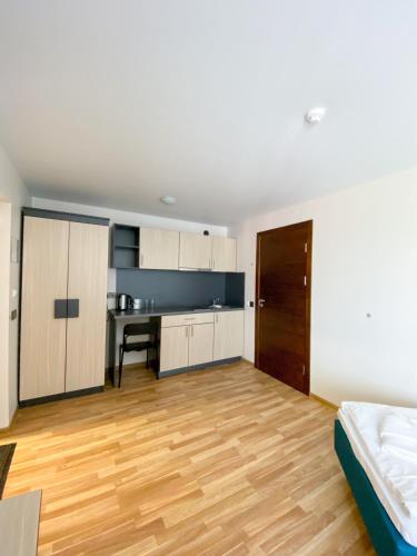 an empty room with a bed and a kitchen at "AVA" apgyvendinimo įstaiga in Vilnius