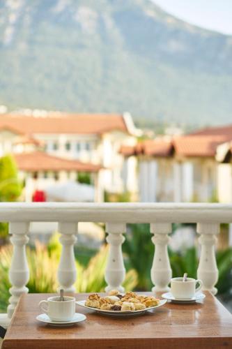 a table with two cups and a plate of food at Larimar Suite Hotel in Oludeniz