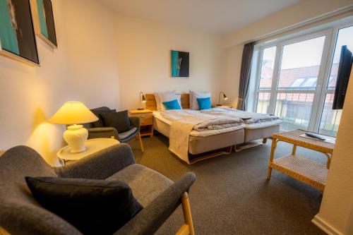 - une chambre avec un lit et un salon dans l'établissement Nymindegab Kro, à Nørre Nebel