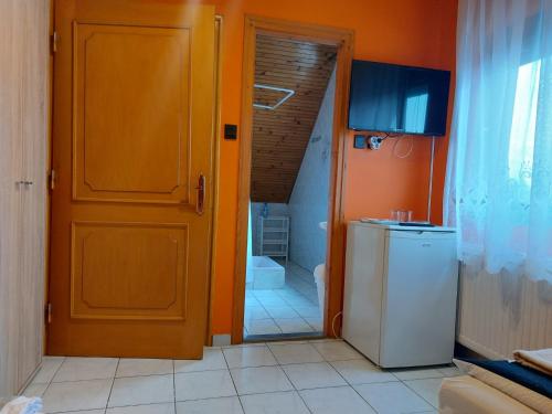 an open door to a bathroom with a refrigerator at Napfény villa in Balatonfüred
