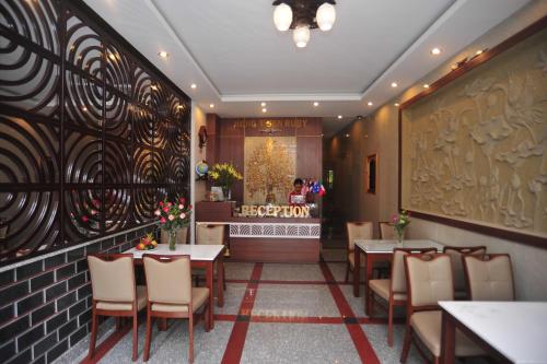 ein Restaurant mit Tischen und Stühlen und eine Bar in der Unterkunft Hong Thien Ruby Hotel in Hue