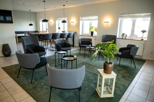 una sala de espera con sillas, una mesa y un bar en Nymindegab Kro, en Nørre Nebel