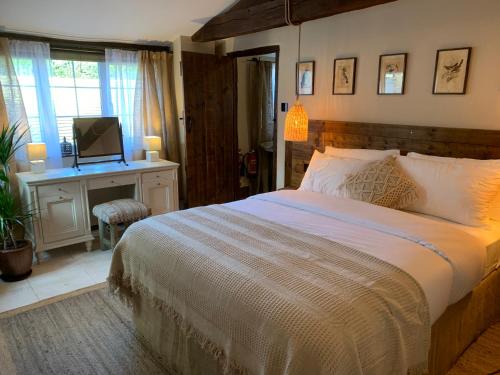 Tempat tidur dalam kamar di Dovecote Cotswold Cottages