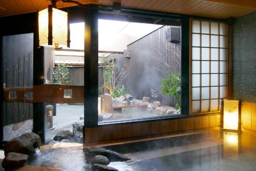 Habitación con piscina de agua y ventana en Dormy Inn Kumamoto Natural Hot Spring en Kumamoto