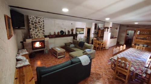 a living room with a couch and a fireplace at El encinar de las Hoces - Vivienda de uso turístico in Castrillo de Sepúlveda
