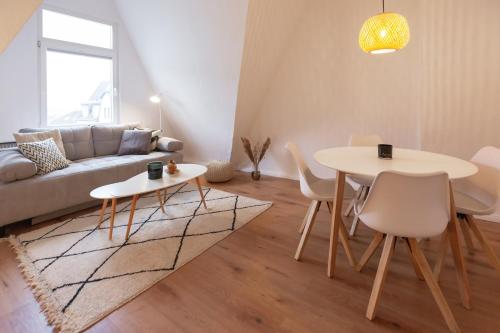 uma sala de estar com uma mesa e um sofá em Bheaven I Skandi Premium Apartment em Bremerhaven