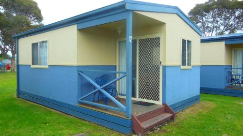 a blue shed with a door and a porch at BIG4 Waters Edge Holiday Park in Lakes Entrance