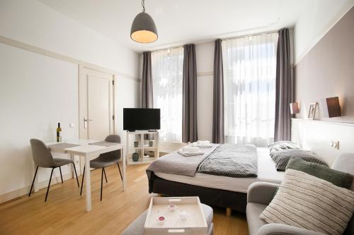 een slaapkamer met een bed, een bank en een tafel bij Four Star Apartments - Berkenbosch Blokstraat in Scheveningen