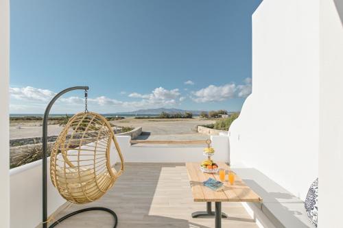 a rattan chair and a table on a balcony at Marine Dream in Plaka