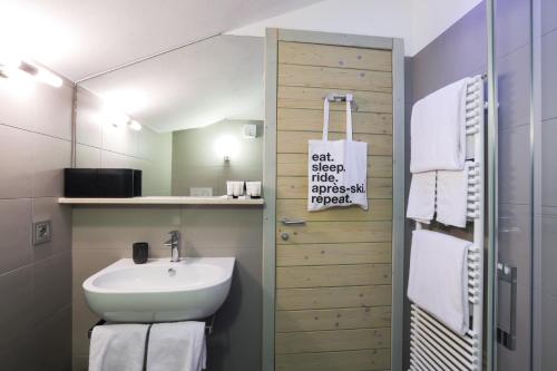 uma casa de banho com um lavatório e um espelho em Super G em Courmayeur