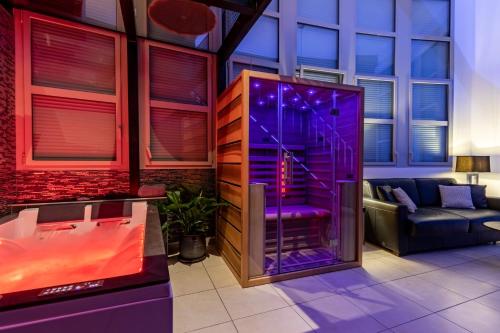 a living room with a hot tub with purple lighting at GlamappartSpa Prestige New-York expérience in Reims