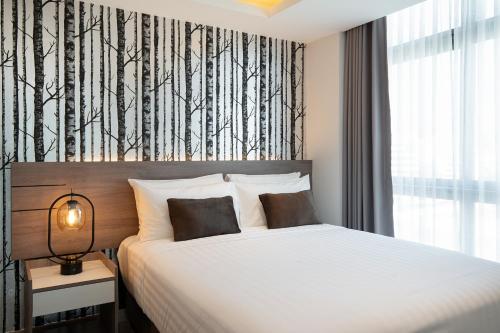 a bedroom with a bed with a black and white wallpaper at ORION Hotel & Residence Bangna in Bangkok