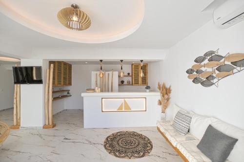 a living room with a white couch and a kitchen at Marine Dream in Plaka