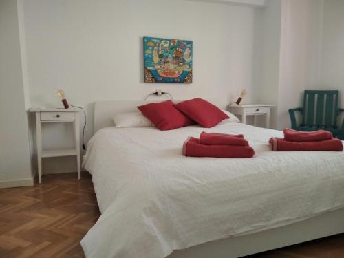 a bedroom with a large white bed with red pillows at Casa Paseo del Tajo-CON PARKING GRATIS - 3 habitaciones in Toledo