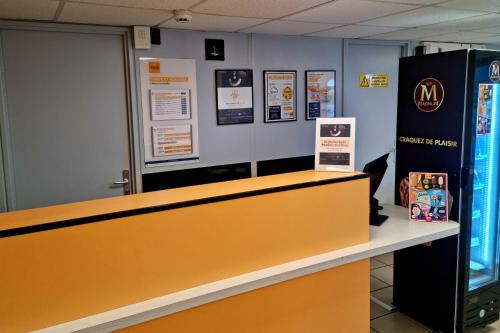 a counter in a store with a sign on the wall at Premiere Classe Honfleur in Honfleur