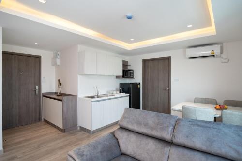 a living room with a couch and a kitchen at ORION Hotel & Residence Bangna in Bangkok