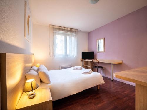 a bedroom with a white bed and white walls at Residhotel St Etienne Centre in Saint-Étienne