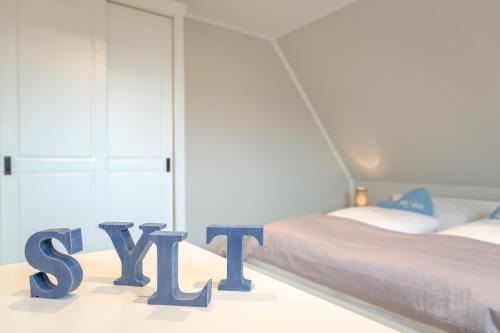 a bedroom with two beds and a sign that says style at Ferienwohnung Ben mit exklusiver Dachterrasse in Tinnum