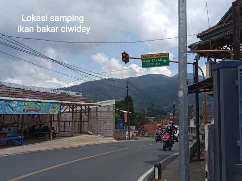 a man riding a motorcycle down a street at Penginapan atau Kontrakan Rumah Ciwidey 1 Ruangan 2 Kasur Dewasa Kamar Mandi Dapur Dalam Sewa Harian Mingguan Bulanan Tahunan Boleh in Ciwidey