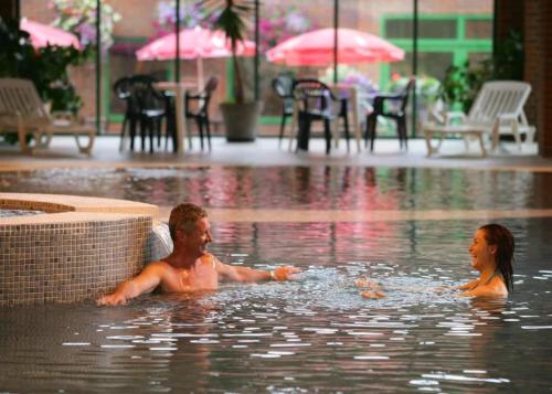 Due persone in una piscina con la pioggia di New Forest Retreat Shorefield Country Park a Lymington