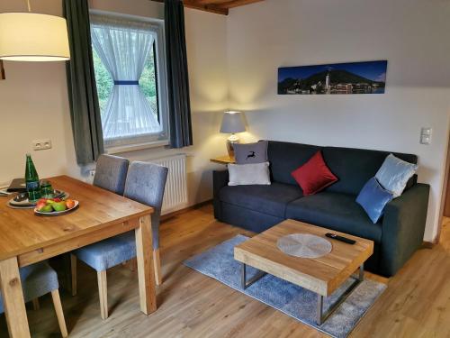 ザンクト・ヴォルフガングにあるApartmenthaus WALDHORNのソファとテーブルのあるリビングルーム