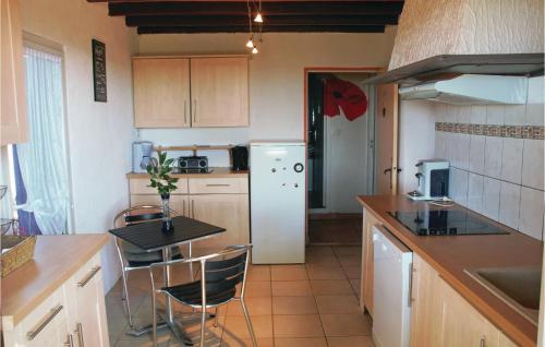 une cuisine avec une table et un réfrigérateur blanc dans l'établissement Gorgeous Home In Lavardac With Kitchen, à Lavardac