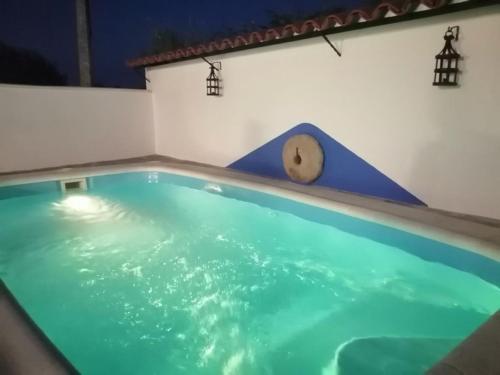 a swimming pool with a clock on top of it at BORBOLETA AZUL ALOJAMIENTO TURISTICO in Villarreal