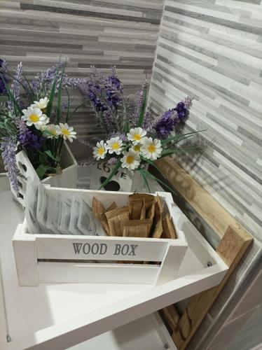 a wooden box with flowers on a table at Home Sweet Home COSENZA in Cosenza