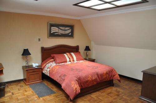 a bedroom with a bed and two night stands and two lamps at Hostal Patrimonio - Sucre in Sucre