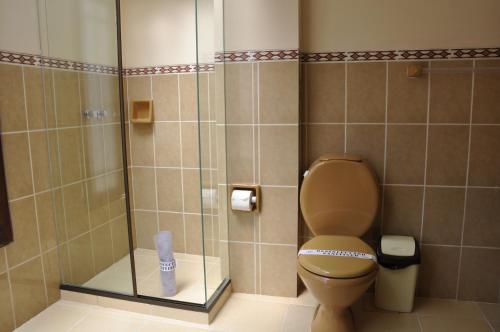 a bathroom with a toilet and a glass shower at Hostal Patrimonio - Sucre in Sucre
