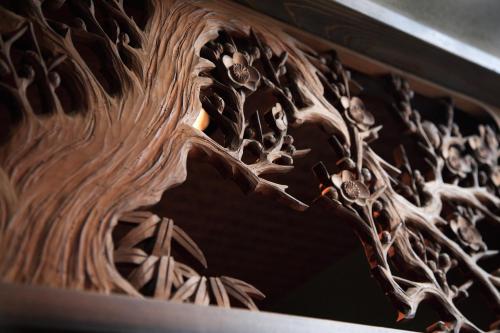 a close up of a wood sculpture of a face at Ryokan Konomama in Minami Aso