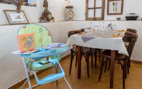 una sala da pranzo con tavolo e seggiolone per bambini di Hotel Pascal ad Allos