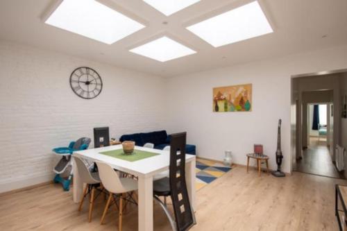 a dining room with a white table and chairs at L'escapade Dieppoise - 3 chambres, 1er étage in Dieppe