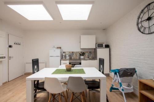 a kitchen with a table and chairs and a clock on the wall at L'escapade Dieppoise - 3 chambres, 1er étage in Dieppe