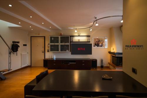 a living room with a table and a tv at Gateway AIRPORT Bari ELEGANT FLAT with car park in Bari